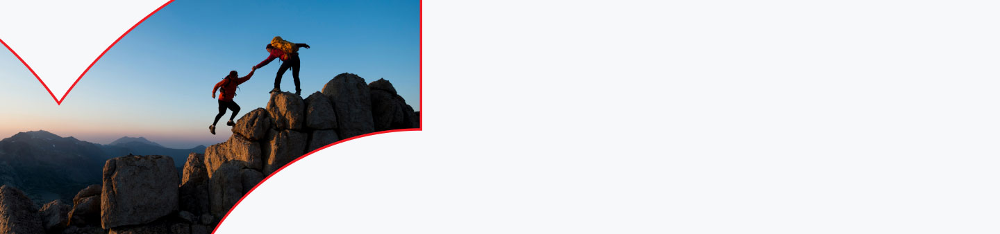 Zwei Personen, die sich beim Bergsteigen helfen